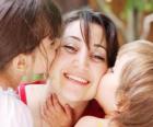 Μαμά ή η μητέρα να λαμβάνει τα φιλιά από τα παιδιά τους